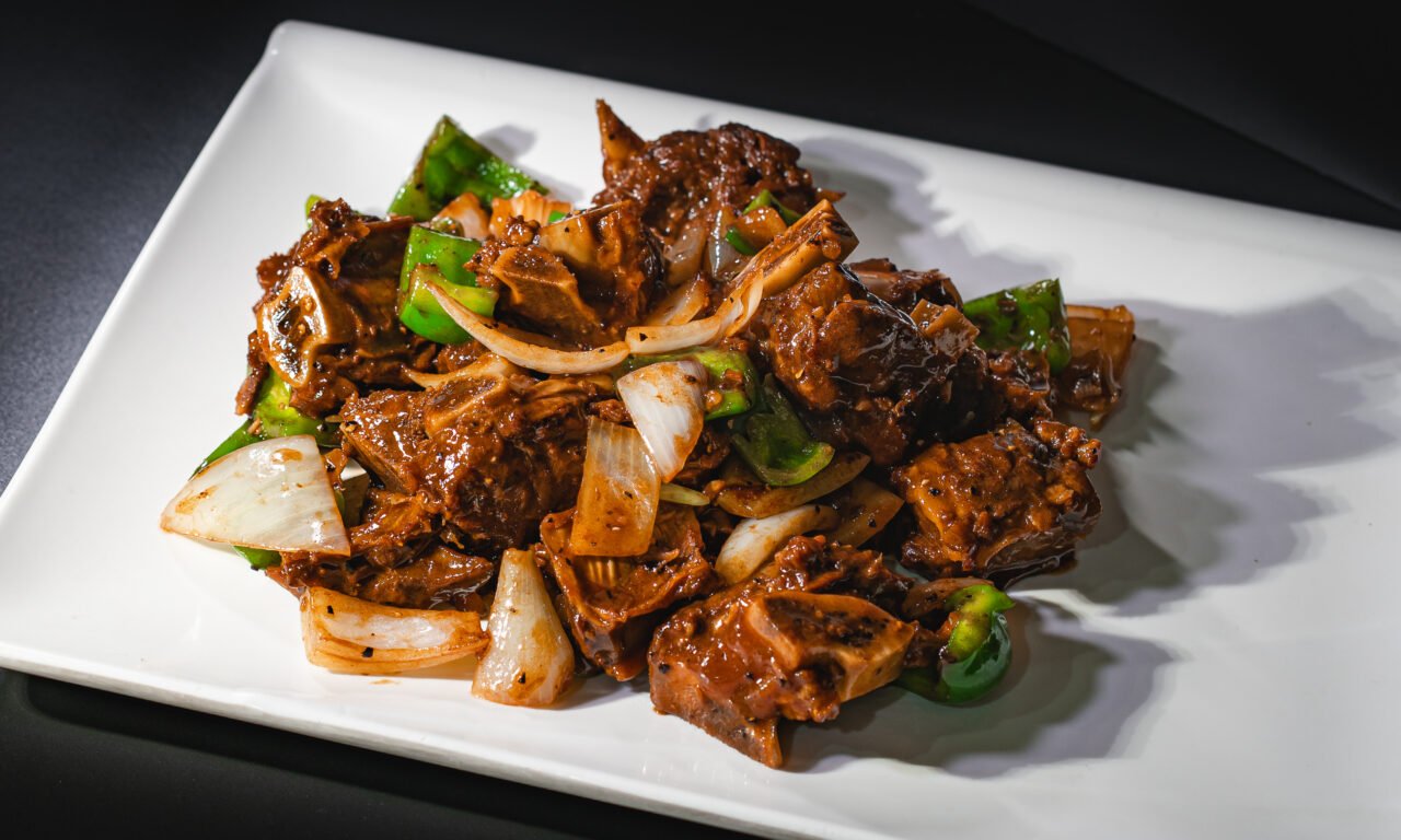 Black bean and pepper braise with onion on a white plate
